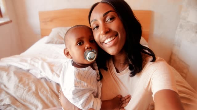 Happy-young-mother-with-little-son-taking-selfies-at-home