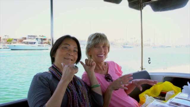 Ältere-kaukasischen-und-asiatischen-Frauen,-albern-und-Spaß-auf-einem-Boot