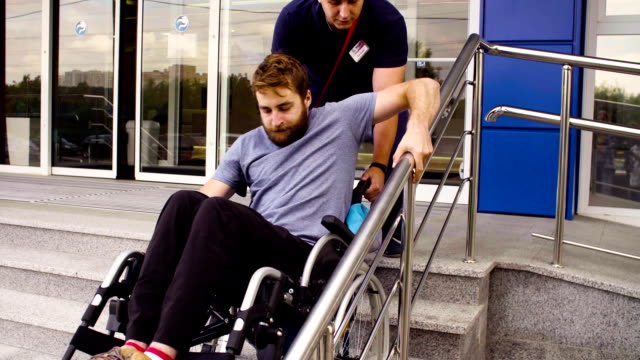 Man-helping-to-move-down-to-a-disabled-man