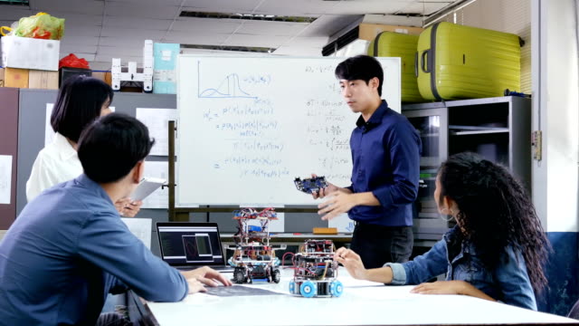 Männliche-Ingenieur-vorliegende-Projekt-mit-Team.-Team-Ingenieur-Inbetriebnahme-für-Roboter-Projekt-zusammen.-Menschen-mit-Technologie-oder-Innovation-Konzept.-4K-Auflösung.
