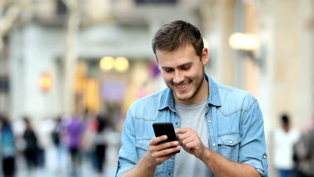 Mann-zu-Fuß-und-mit-Hilfe-ein-smart-Phone-auf-der-Straße