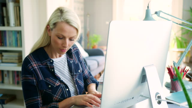 Beautiful-Blond-Businesswoman-Typing-On-Computer-At-Home-Office