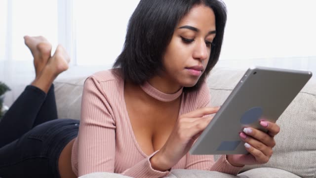 Teenage-girl-using-digital-tablet-on-sofa