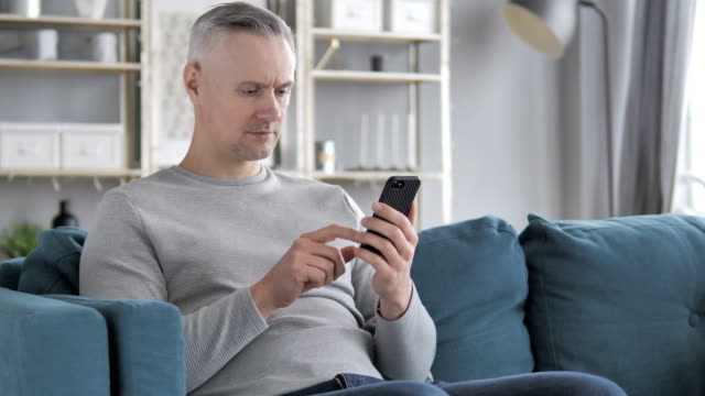 Hombre-de-pelo-gris-navegación-en-Smartphone,-usando-Internet