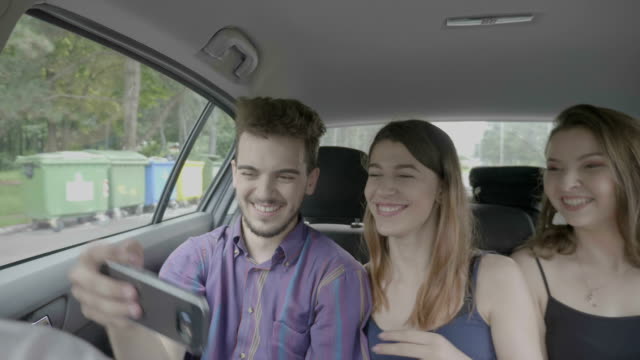 Tausendjährige-Gruppe-von-verrückten-Freunde-unter-Selfie-Bumerang-video-in-einem-Auto,-während-sie-gehen-auf-Reise,-schreiend-und-herumalbern-vor-Smartphone-Kamera