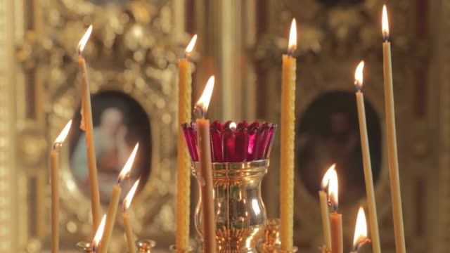 Las-velas-se-queman-en-una-catedral-cristiana,-nadie,-el-oro-está-en-todas-partes,-fuego,-iconos,-vídeo-4k