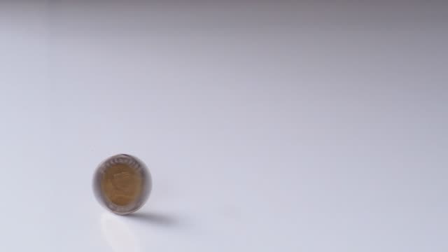 Geldmünze-rotieren-und-auf-weißem-Tisch-drehen.-Business-Economy-Finanzkonzept.-Bewegung-4k-b-Roll-Filmmaterial