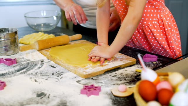 Pequeña-niña-haciendo-galletas-de-Pascua-con-la-abuela