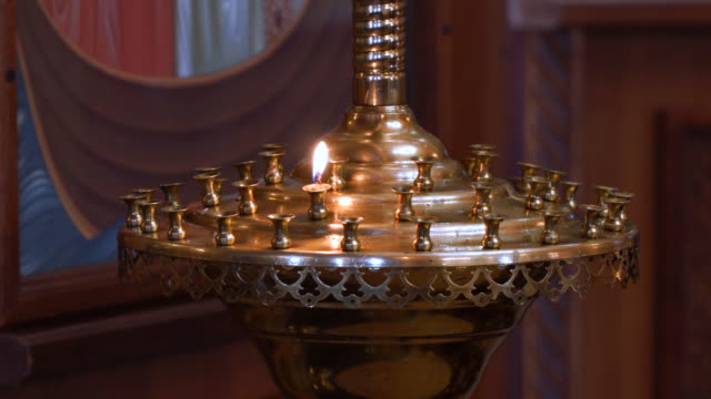 Eine-kleine-Kerze-in-einem-Kerzenständer-in-der-Kirche
