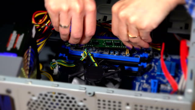 installing-RAM-computer-memory-lath-into-socket-by-expert-female-hand
