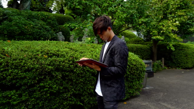 Young-Asian-Architecture-Student-Using-Tablet-To-Sketch-Outdoors