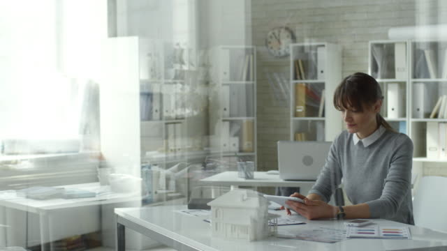 Weibliche-Architektin-nutzt-digitales-Tablet-am-Office-Desk