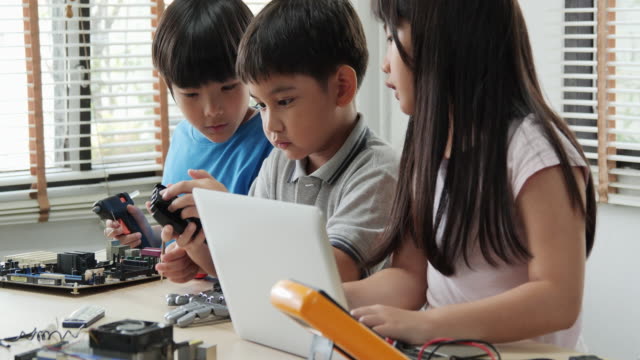 Kinder-Ingenieur-Team-zusammen-arbeiten,-Montage-und-Prüfung-an-Geräten-in-der-Werkstatt.-Menschen-mit-Technologie-und-Innovationskonzept.
