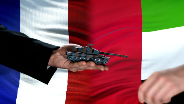 France-and-UAE-officials-exchanging-tank-money,-flag-background,-military-forces