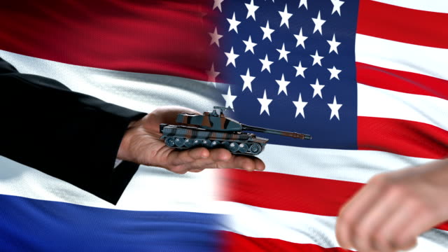 Netherlands-and-USA-officials-exchanging-tank-money,-flag-background,-politics