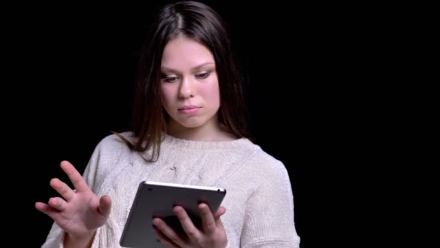 Nahaufnahme-von-jungen-attraktiven-kaukasischen-Frau-mit-dem-Tablet-und-Reaktion-auf-Social-Media-Beiträge-vor-der-Kamera