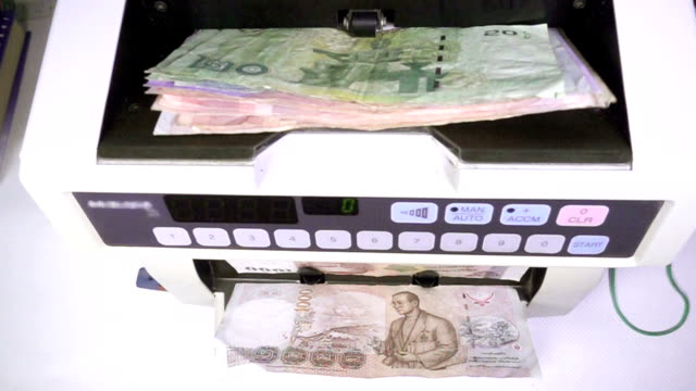 Electronic-money-counter-machine-is-counting-Thai-baht-THB
