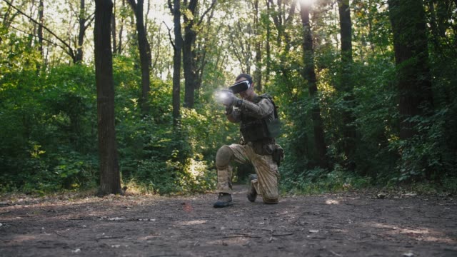 Soldier-aiming-with-gun-wearing-virtual-reality-glasses-outdoors