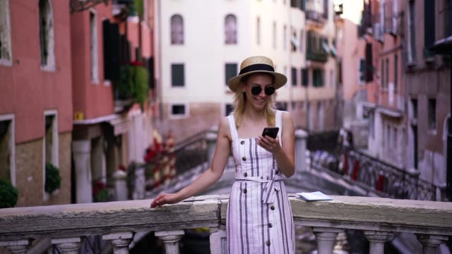 Slow-motion-effect-of-young-cheerful-female-tourist-reading-received-message-from-friend-with-funny-information