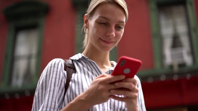 Smiling-female-hipster-enjoying-time-for-updating-social-profile-on-website-for-meeting-new-virtual-people-using-public-internet-connection-during-sightseeing-on-vacations