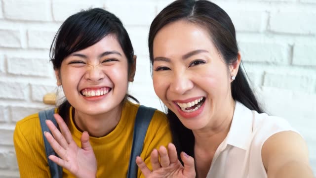 Glückliche-asiatische-Teenager-Tochter-und-Mitte-Alter-Mutter,-die-Selfie-oder-Video-Anrufe