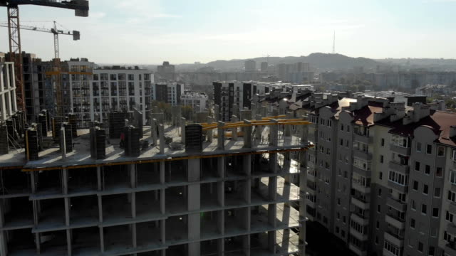Flight-near-the-unfinished-monolithic-house.-Construction-crane-near-the-construction-site.-Top-view-of-the-construction