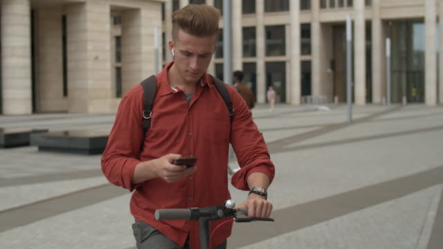 Hipster-Man-usando-E-scooter-y-teléfono-móvil
