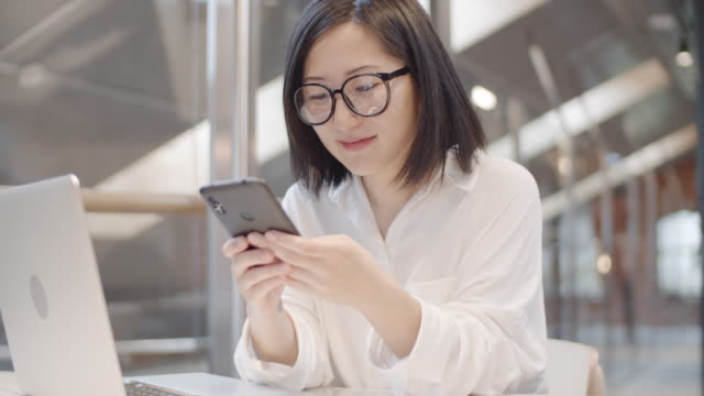 Mujer-asiática-usando-el-teléfono-en-el-lugar-de-trabajo