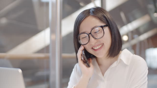 Lächelnde-weibliche-Büroangestellte-mit-Telefon-Chat