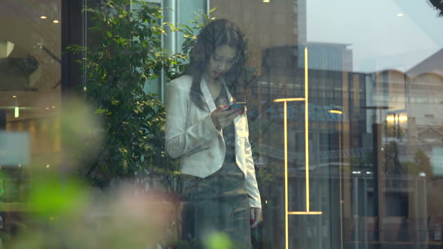 Geschäftsfrau-asiatische-Geschäftsfrau-mit-Smartphone-im-Bürogebäude