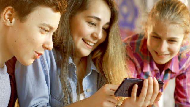 Junge-und-zwei-Mädchen-an-einem-Schulen-Wissenschaft-Klassenprojekt-Videos-beliebte-auf-Smartphone.
