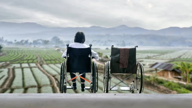 Elderly-woman-with-empty-wheelchair-standing-together