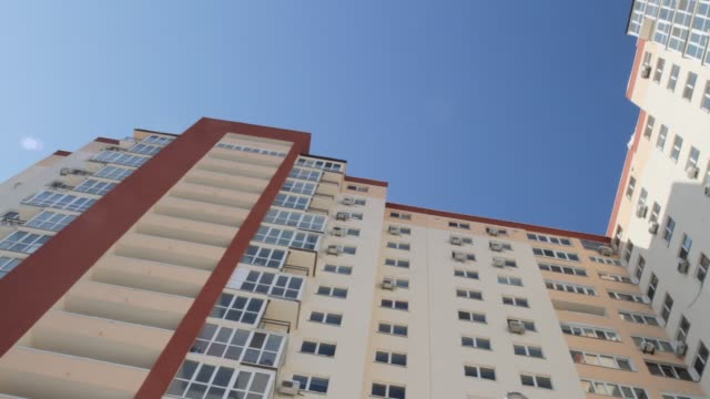 moderno-edificio-de-apartamentos---ventanas-pisos---balcón-----cielo-azul.