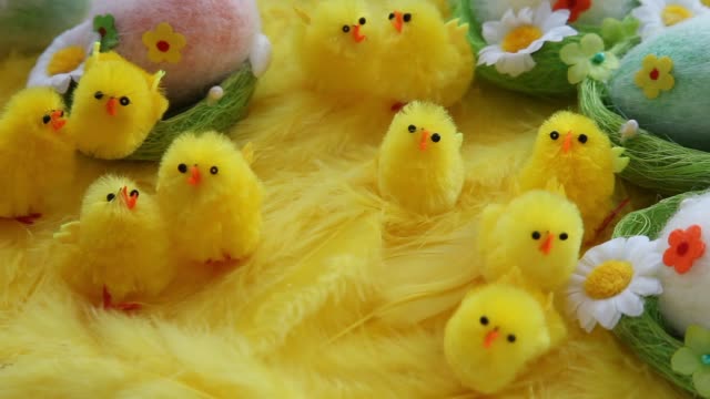 Bebé-amarillo-Pascua-juguetes-polluelos-y-huevos-sobre-un-fondo-de-plumas.-Tarjeta-de-felicitación-video-fiesta