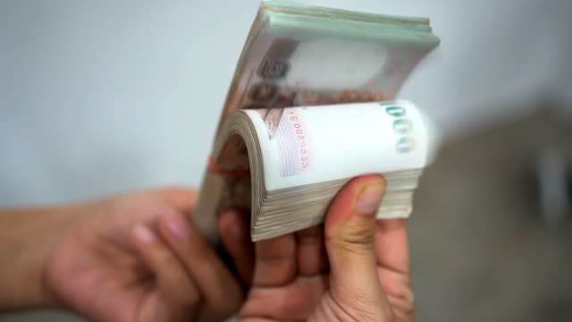 Close-up-hands-counting-of-thousansds-Thai-baht-money