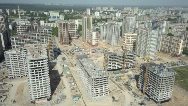Aerial-view.-Construction-of-a-modern-district-with-residential-apartments-and-developed-infrastructure.-A-construction-site-with-cranes-and-tall-buildings.-Sale-and-rental-of-real-estate
