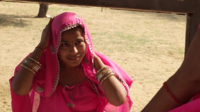 Mujer-de-Rajasthani-ajustando-su-sari-rosa-y-prepara-delante-de-un-espejo-exterior