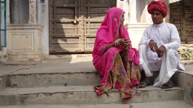 Indische-Paare-vor-alten-Rajasthani-Architektur-sitzen-und-plaudern