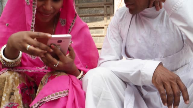 Tilt-up-to-Rajasthani-couple-in-traditional-dress-in-from-of-traditional-house-text-message-notification