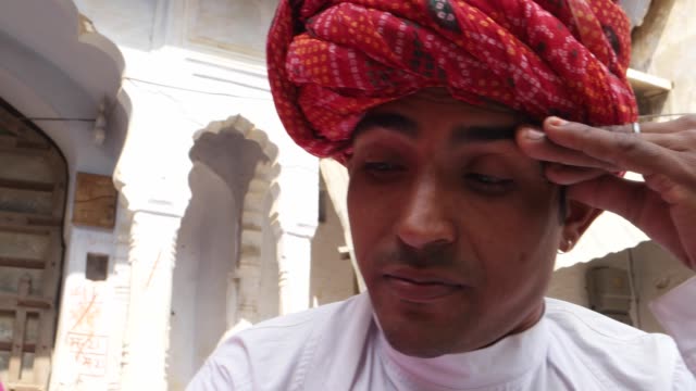 Close-up-of-Rajasthani-couple-tense-worried-sweating-remorse-in-traditional-dress-in-from-of-traditional-architecture-gate