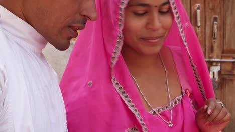 Buenas-mira-par-compras-felices-juntos-compartiendo-vida-amor-en-Rajasthan,-India-recién-casados-rojo-rosa