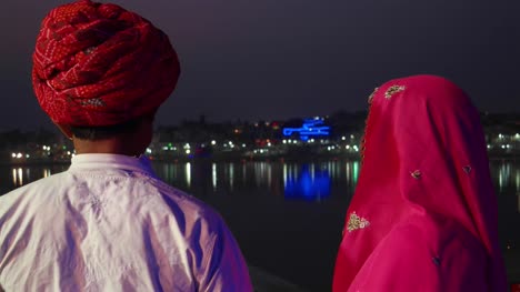 India-pareja-tradicional-en-el-lago-de-Pushkar-en-noche