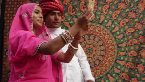 Mujer-en-un-sari-rosa-se-une-a-su-hombre-y-toman-autorretratos-en-una-cámara-de-teléfono-móvil