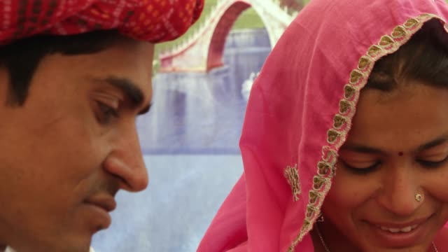 Nahaufnahme-des-indischen-Ehepaar-eine-Diskussion-mit-einem-farbigen-Hintergrund-sitzen