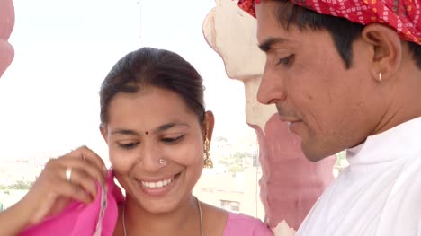 Par-de-Rajastán-con-un-elegante-reloj-de-trabajo-aprendizaje-enseñanza-compartiendo-vestida-con-sari-rosa-y-turbante-rojo-en-la-India