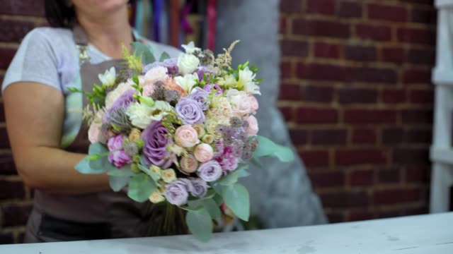 Floreria-profesional-presentando-la-boda-ramo-de-flores-en-estudio-de-diseño-floral