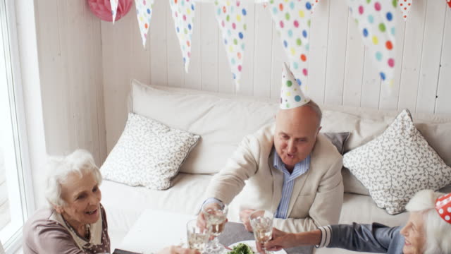 Senioren-Freunde-trinken-Champagner-auf-Geburtstagsparty