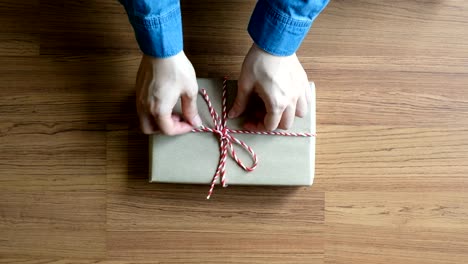 Woman-wrapping-christmas-presents-on-wooden-desk-hands-from-above,-Top-view
