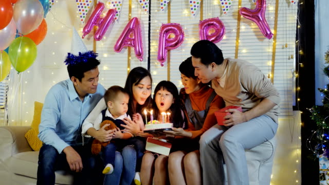 People-blows-out-candles-on-birthday-cake-at-party-with-happy-emotion.-People-with-party-and-celebration-concept.-4K-Resolution.