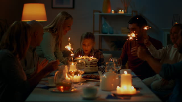 Geburtstagsfeier-der-niedliche-kleine-Mädchen-am-Tisch,-Mutter-bringt-Kuchen-und-Mädchen-bläst-Kerzen.-Glücklich-Verwandten-und-Freunden-am-Tisch-versammelt,-um-zu-feiern.